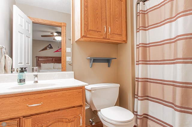 bathroom featuring a textured ceiling, toilet, vanity, and ceiling fan