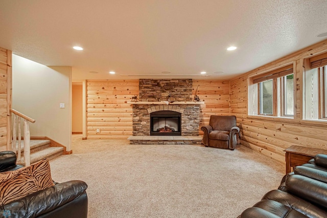 carpeted living room featuring a textured ceiling, a fireplace, and log walls