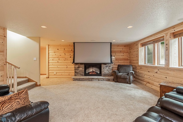 living room with carpet floors, a fireplace, a textured ceiling, and rustic walls