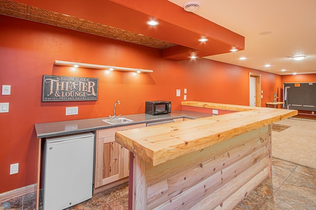 kitchen with refrigerator, dark tile patterned flooring, sink, and light brown cabinetry