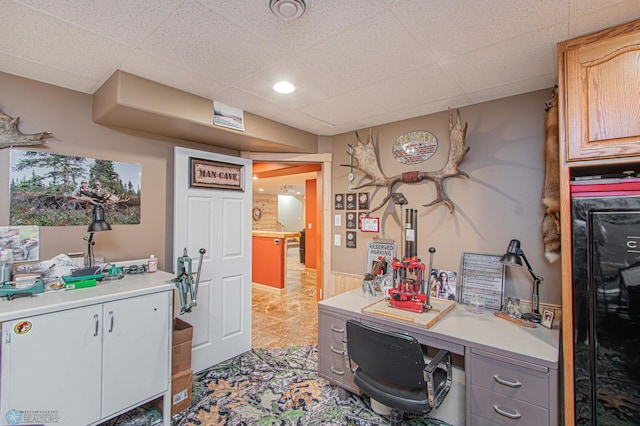 office area with light tile patterned flooring and a drop ceiling