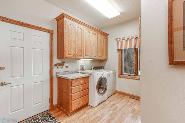 clothes washing area with cabinets, independent washer and dryer, and light wood-type flooring