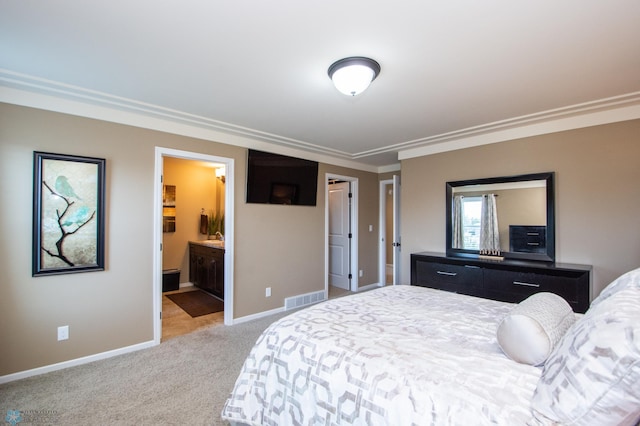 bedroom with ornamental molding, light carpet, and ensuite bathroom