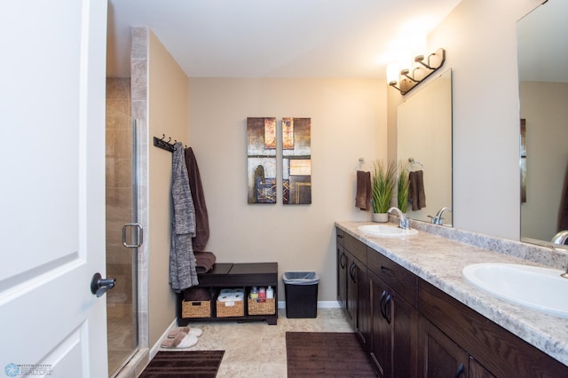 bathroom with a shower with door, tile patterned flooring, and dual bowl vanity