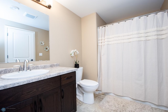 bathroom featuring vanity, tile patterned flooring, and toilet