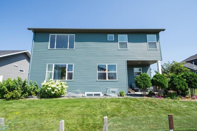 rear view of property with a lawn and cooling unit