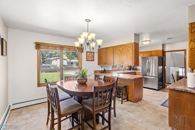 dining space with baseboard heating, a textured ceiling, light tile patterned floors, and a chandelier