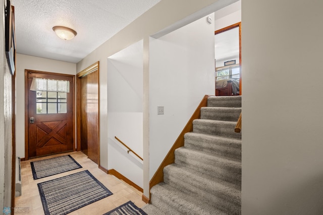 tiled entryway featuring a textured ceiling