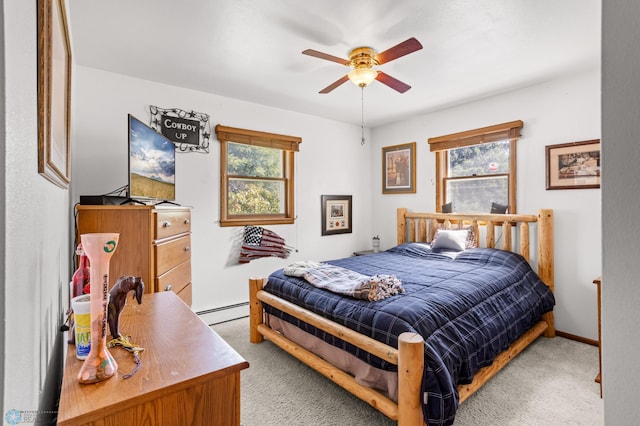 carpeted bedroom with a baseboard heating unit and ceiling fan