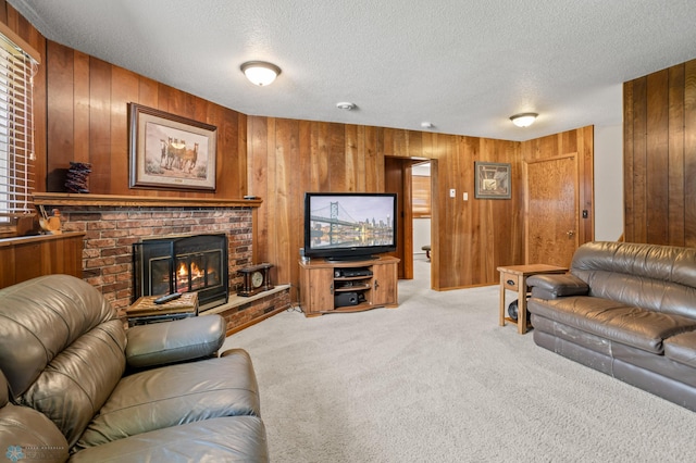 carpeted living room featuring wood walls, a fireplace, and a textured ceiling