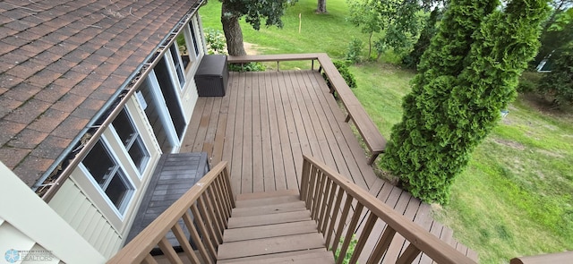 wooden deck featuring a lawn