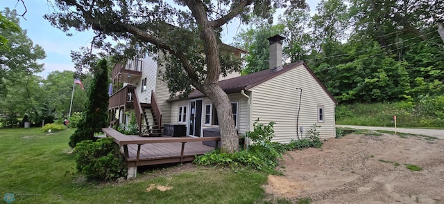 view of home's exterior featuring a wooden deck and a lawn