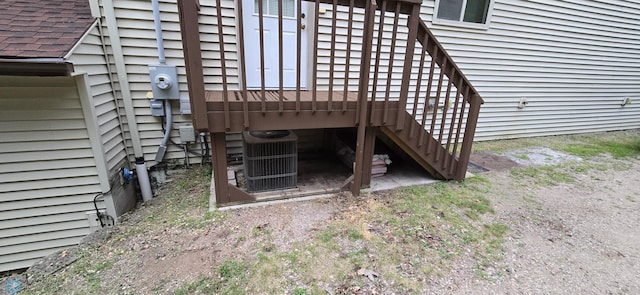 doorway to property featuring cooling unit and a wooden deck