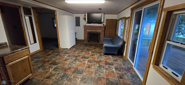 unfurnished living room with crown molding, a brick fireplace, and dark tile patterned flooring