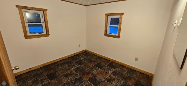 empty room with crown molding and dark tile patterned flooring