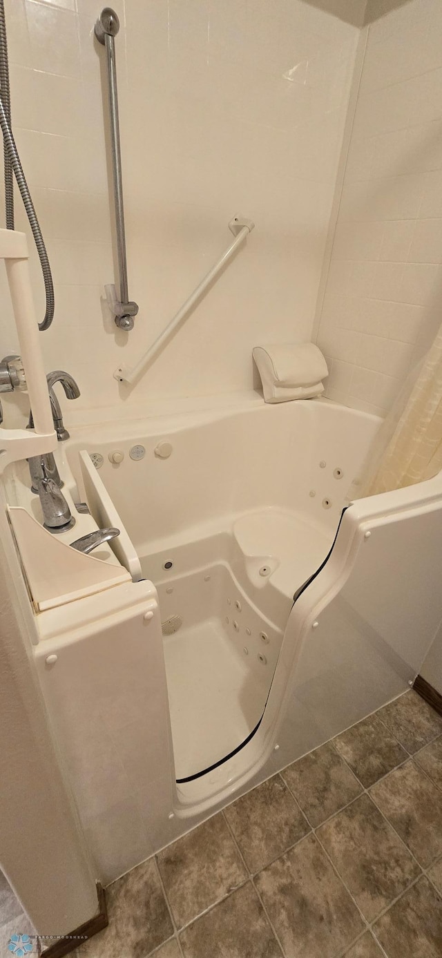 bathroom with tile patterned floors and washtub / shower combination