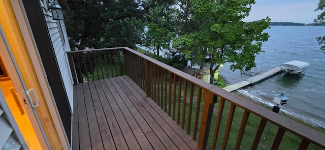 wooden deck with a water view and a boat dock