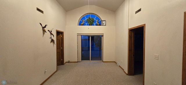 corridor featuring light carpet and high vaulted ceiling