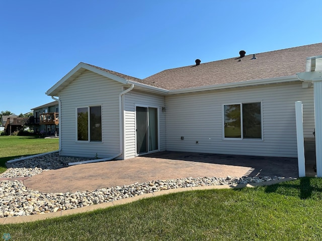 back of property featuring a patio area and a yard