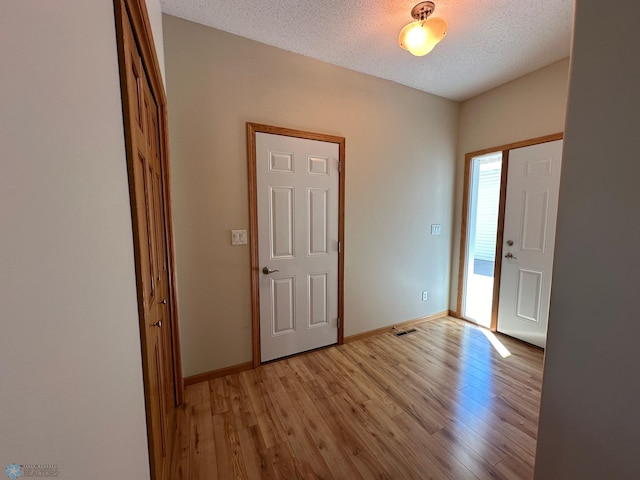 entrance foyer featuring light hardwood / wood-style floors and a textured ceiling