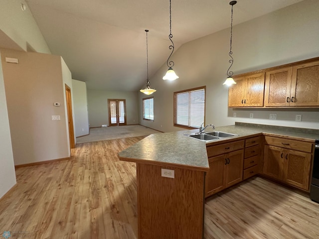 kitchen with sink, kitchen peninsula, hanging light fixtures, and light hardwood / wood-style floors