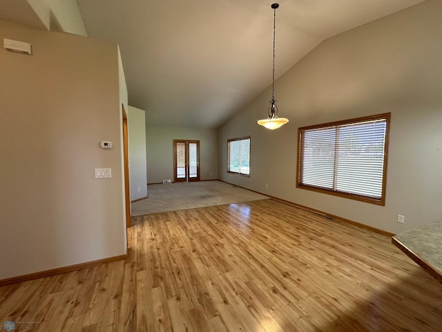 interior space featuring light colored carpet and high vaulted ceiling