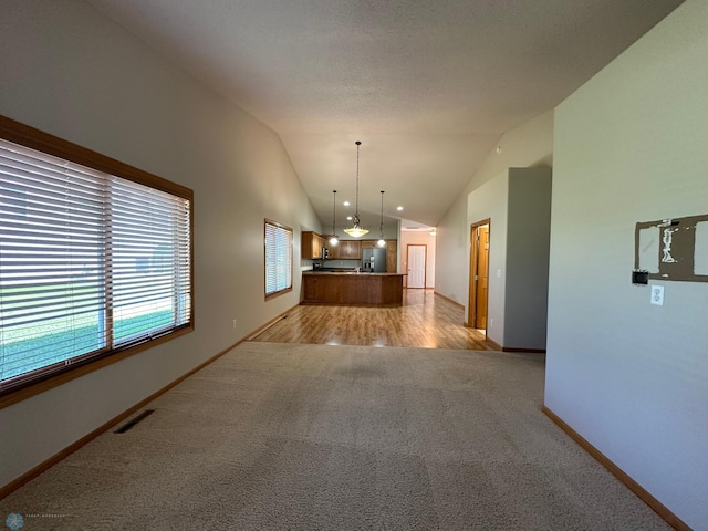 interior space featuring light carpet and high vaulted ceiling