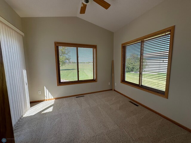 carpeted empty room with ceiling fan and vaulted ceiling