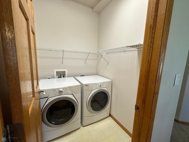 clothes washing area with light tile patterned floors and washing machine and clothes dryer