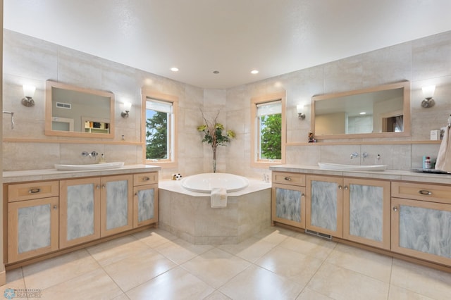 bathroom with tiled tub, vanity, and tile walls