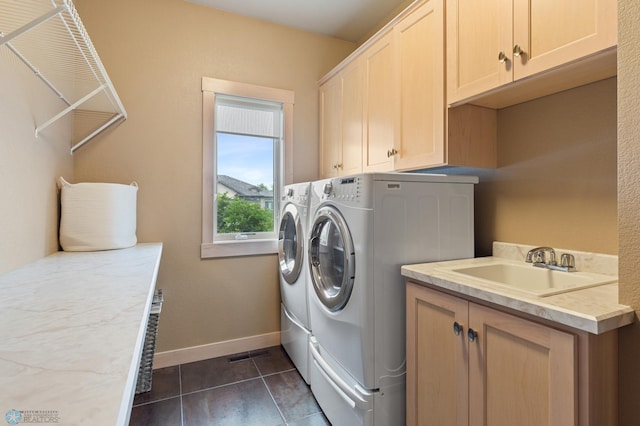 washroom featuring cabinets, dark tile patterned flooring, sink, and independent washer and dryer