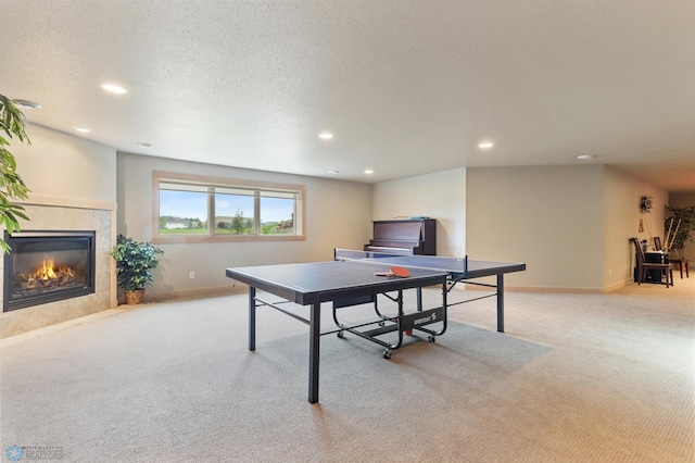 rec room featuring a fireplace, a textured ceiling, and light carpet