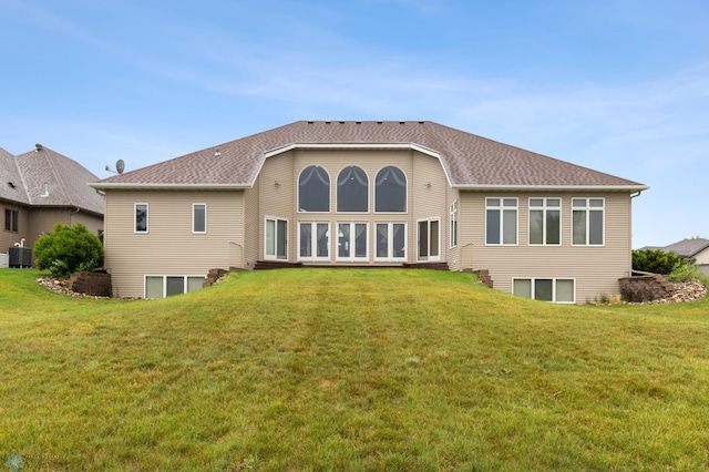 back of property with cooling unit and a lawn