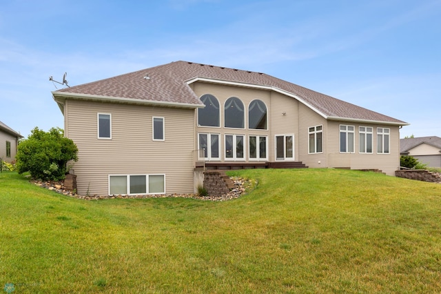 rear view of house featuring a lawn