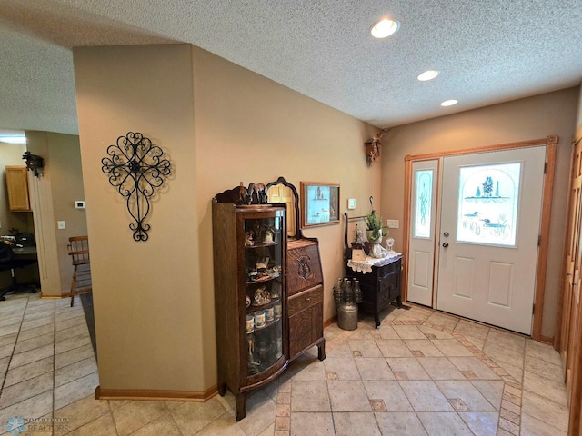 tiled foyer entrance featuring a textured ceiling