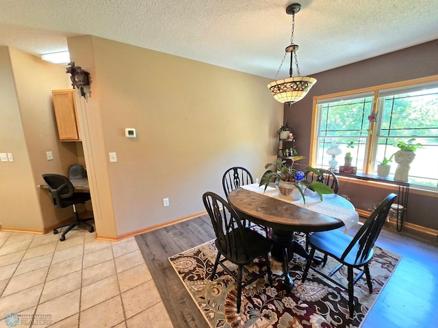 dining space with a textured ceiling and light wood-type flooring