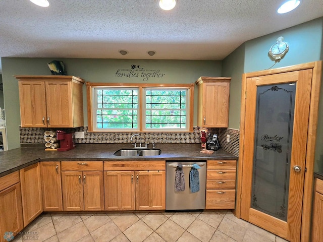 kitchen with light tile patterned floors, tasteful backsplash, sink, and stainless steel dishwasher