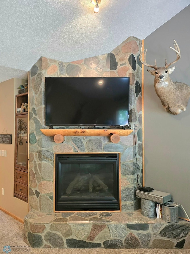 interior details with a fireplace, carpet, and a textured ceiling