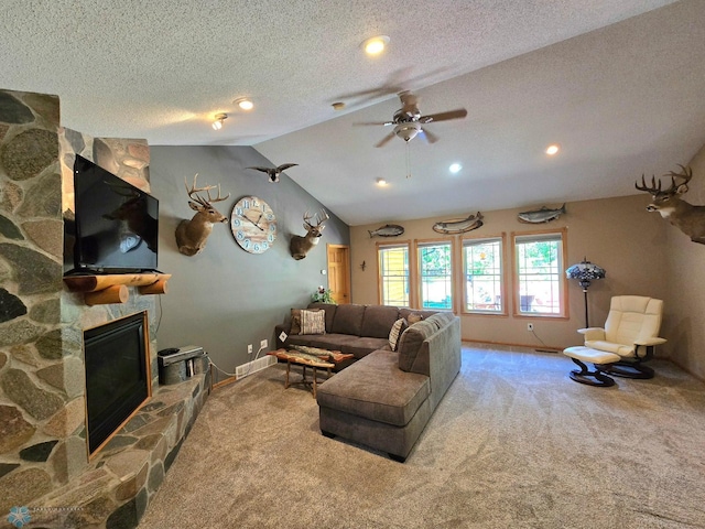 living room with a stone fireplace, light carpet, vaulted ceiling, and ceiling fan