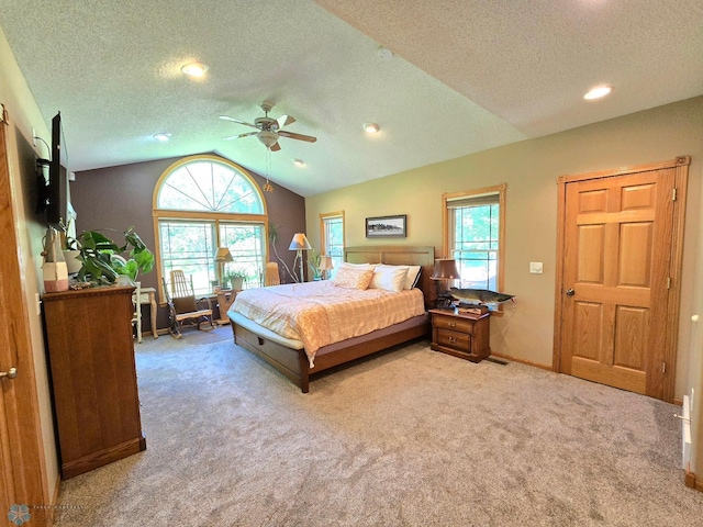 carpeted bedroom with a textured ceiling, ceiling fan, and vaulted ceiling