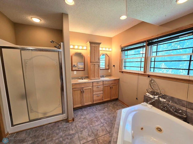 bathroom with dual vanity, an enclosed shower, a textured ceiling, and tile patterned floors