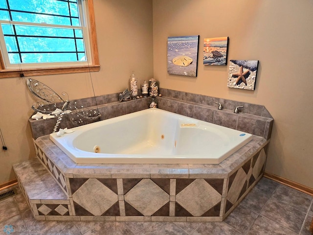 bathroom with tiled tub and tile patterned floors