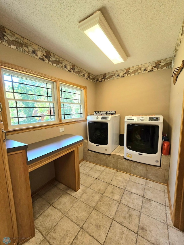 laundry area featuring independent washer and dryer, a wealth of natural light, cabinets, and a textured ceiling