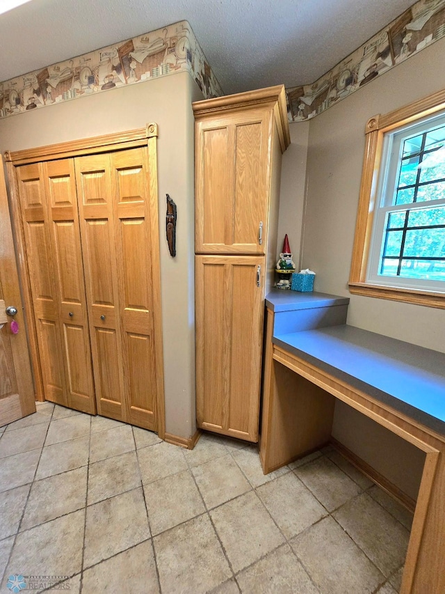 interior space featuring tile patterned flooring and a textured ceiling