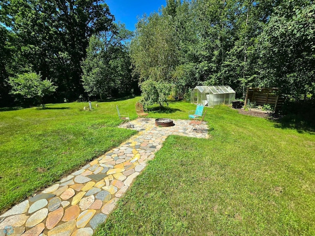 view of yard with a fire pit and a storage shed