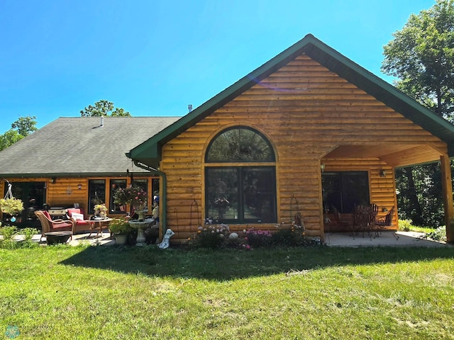 rear view of house with a patio and a lawn