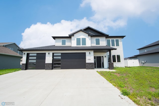 view of front of property featuring a garage and a front lawn