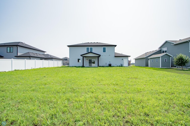 rear view of property featuring a lawn