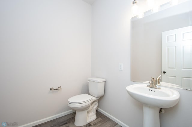 bathroom with hardwood / wood-style flooring and toilet