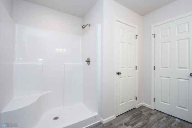 bathroom with walk in shower and hardwood / wood-style floors